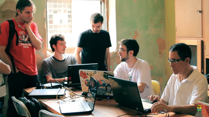 Participantes trabalham em seus notebooks ao redor de uma mesa durante o ODD Porto Alegre 2015.